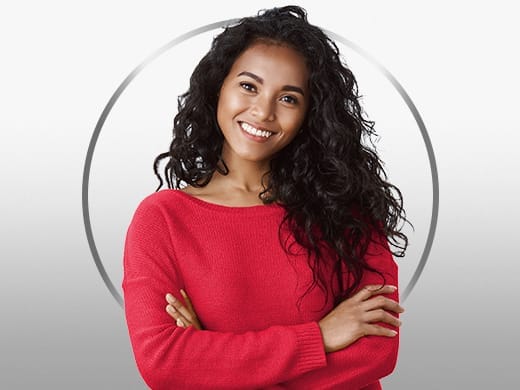Mulher sorridente, usando um suéter vermelho, feliz após o tratamento com Gino-Canesten